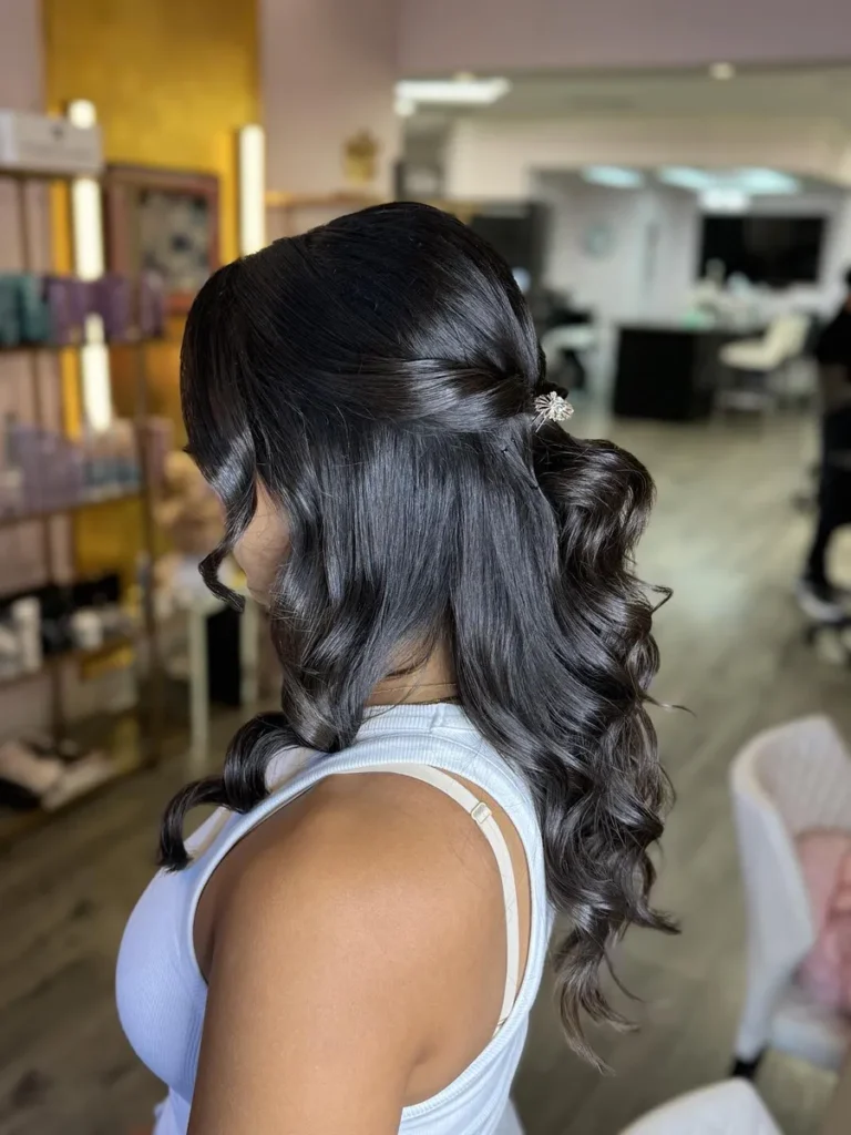 Bride with shiny curled hairstyle and delicate side hair clip styled for wedding day