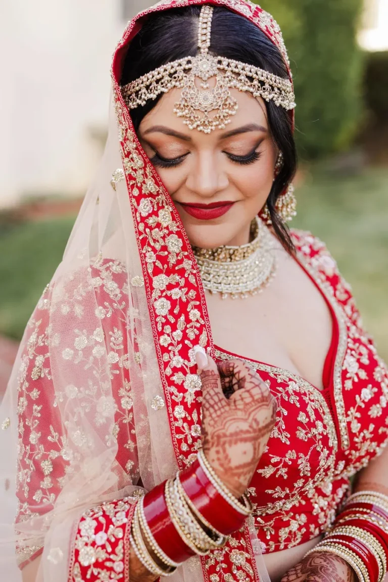 Bride in a traditional red and gold outfit with intricate henna and bridal jewelry