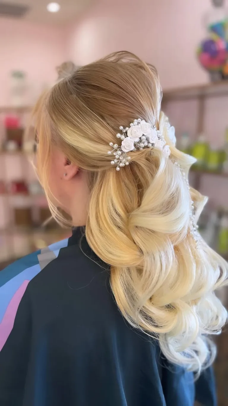 Soft blonde bridal curls styled with a delicate white floral hairpiece